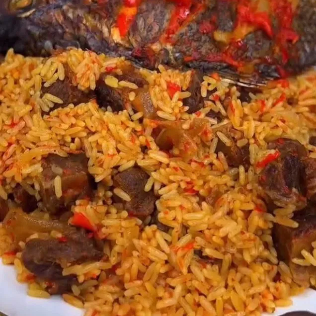 A plate of jollof rice with beef and fried fish
