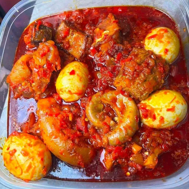 Pepper stew with boiled eggs and assorted meat in a takeaway tub